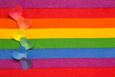 Gökkuşağı LGBT bayrağında renkli kağıt kalpler. Sevgililer Günü kutlaması
