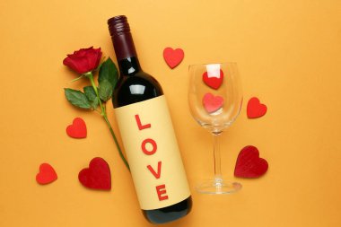Turuncu arka planda Sevgililer Günü için şarap, gül çiçeği ve cam karışımı.