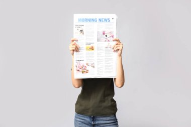 Gri arka planda gazetesi olan kadın.