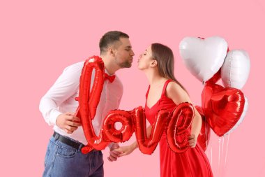 Aşk sözcükleriyle pembe arka planda öpüşen balonlardan yapılmış sevimli bir çift. Sevgililer Günü kutlaması