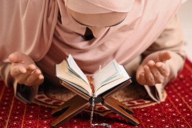 Kur 'an okuyan genç Müslüman kadın, yakın çekim.