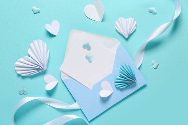 Boş kartlı kompozisyon, kağıt kalpler ve renk arkaplanlı kurdele. Sevgililer Günü kutlaması