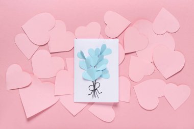 Güzel tebrik kartı ve pembe arka planda kağıt kalpli kompozisyon. Sevgililer Günü kutlaması