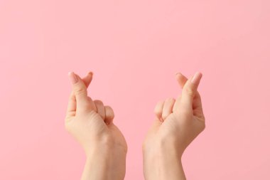 Pembe arka planda kalp hareketi gösteren kadın elleri. Sevgililer Günü kutlaması