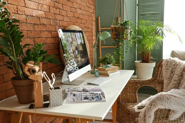 Modern workplace with computer and green plants in office
