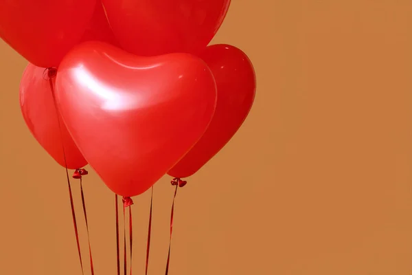 Red heart-shaped balloons for Valentine\'s Day celebration on color background, closeup
