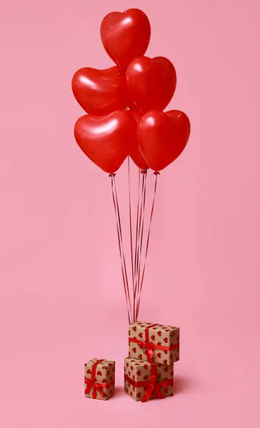 Beautiful heart-shaped balloons and gifts for Valentine's Day celebration on pink background