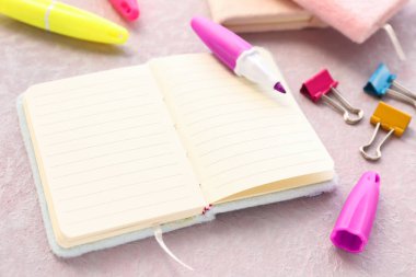 Boş açık defter, işaretleyiciler ve hafif arkaplan üzerindeki klasör klipleri, kapat