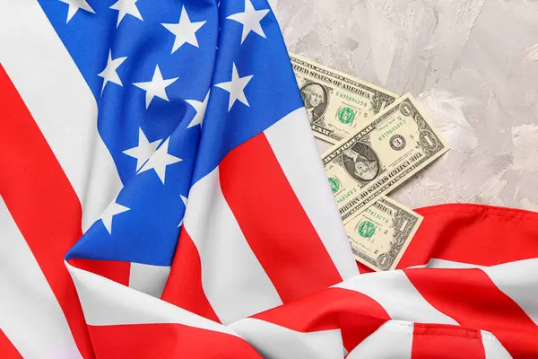 ABD bayrağı ve gri arka planda dolar banknotları