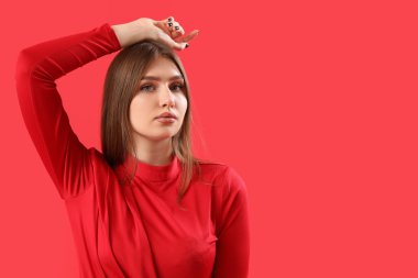 Pretty stylish young woman on red background