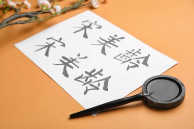 Üzerinde Asya hiyeroglifleri, mürekkep ve kalem olan bir sayfa kağıt, yakın plan. Uluslararası Haiku Şiir Günü