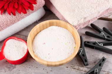 Ahşap arka planda çamaşır deterjanı ve mandallar