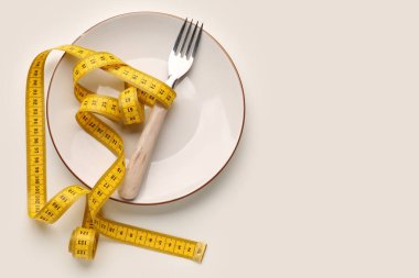 Işık arkaplanındaki yeni mezura, plaka ve çatal