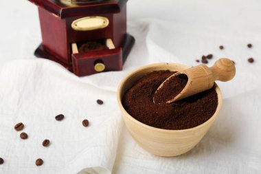 Bir kase kahve tozu, beyaz peçeteyle kepçe, yakın plan.