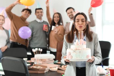 Doğum günü pastalı genç bir kadın ofiste dilek diliyor.