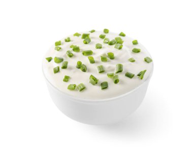 Beyaz arka planda yeşil soğanlı bir kase lezzetli ekşi krema