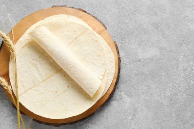 Gri arkaplanda taze lavaş olan ahşap tahta.