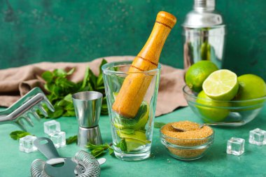 Masada mojito hazırlamak için havan ve malzeme dolu bir bardak.