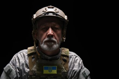 Esmer arka planda Ukrayna yaması olan olgun asker, yakın plan.