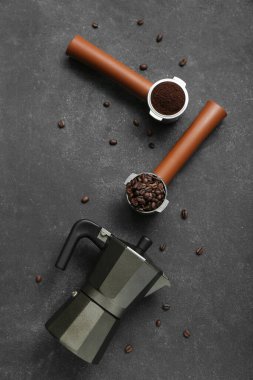 Gayzer kahve makinesi, kahve çekirdekleri ve koyu arkaplanda pudra.