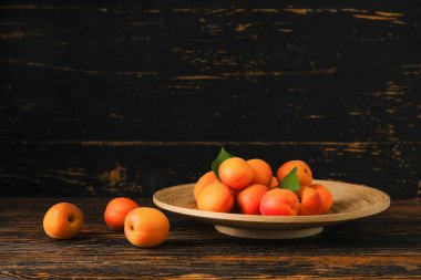 Ahşap arka planda taze kayısı tabağı