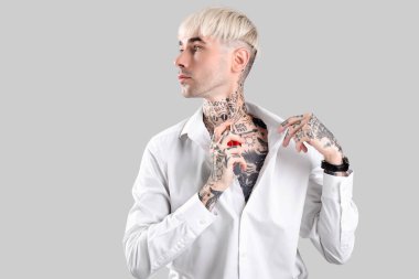 Parfümlü dövmeli genç bir adam.