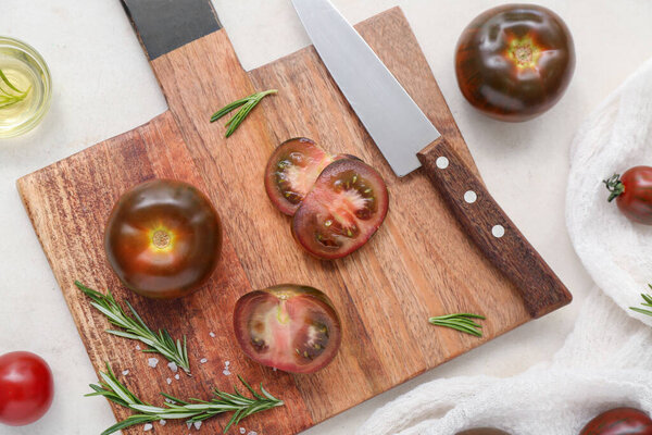 Board with fresh tomatoes and rosemary on white background