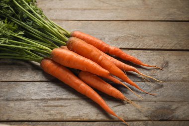 ahşap arka plan üzerinde yaprakları ile taze havuç