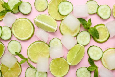 Limon dilimleri, nane ve pembe arka planda buz küplü salatalık. Mojito için gerekenler