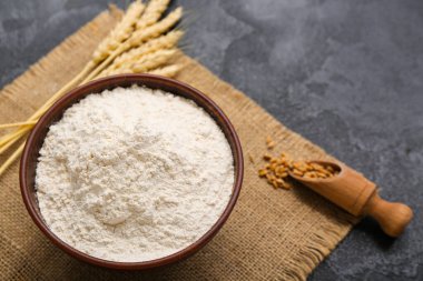 Siyah grunge arkaplanda buğday unu ve dikenli kase.