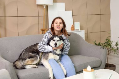 Evde köpekli mutlu genç bir kadın.