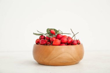 Beyaz arka planda taze gül böğürtlenli ahşap kase.