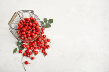 Taze böğürtlenli sepet ve beyaz arka planda yapraklar.