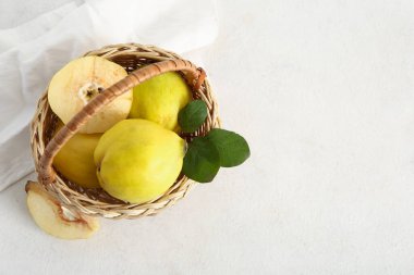 Tatlı olgun bıldırcınlar ve beyaz arka planda yapraklarla dolu bir sepet.