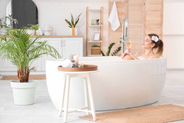 Şampanyalı güzel kadın evde banyo yapıyor.