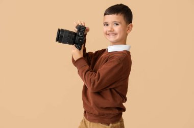 Bej arka planda kamera olan şirin bir fotoğrafçı. Karşıt Gün kutlamaları