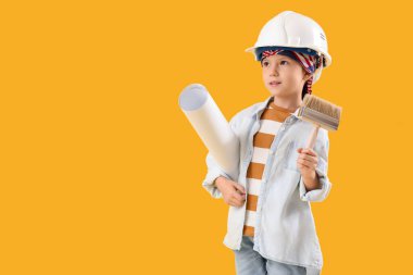 Sarı arka planda boya fırçası ve ev planı olan şirin bir dekoratör. Karşıt Gün kutlamaları