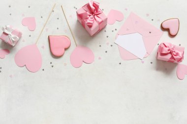 Kalp şeklinde tatlı kurabiyeler ve beyaz arka planda zarf olan hediye kutuları. Sevgililer Günü kutlaması