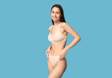 Mavi arka planda iç çamaşırlı güzel bir kadın. Epilasyon kavramı