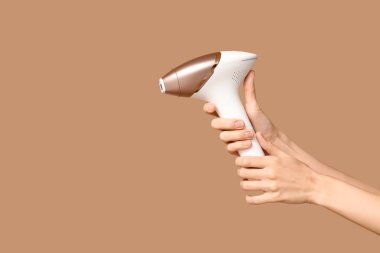 Kahverengi arka planda modern fotoğraf makinesi olan kadın elleri