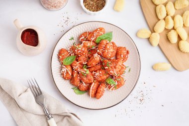 Beyaz arka planda peynirli lezzetli bir gnocchi tabağı.