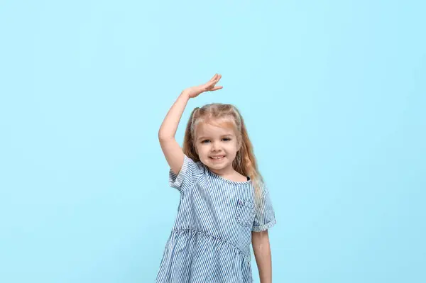 Симпатична Маленька Дівчинка Вимірює Висоту Синьому Фоні — стокове фото