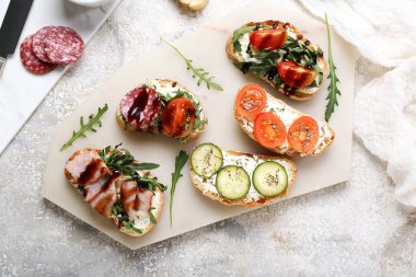 Grunge arka planında lezzetli sandviçler olan tahta