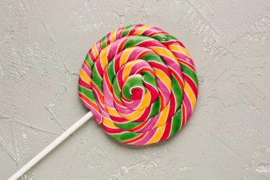 Gri grunge masasında renkli lolipop.