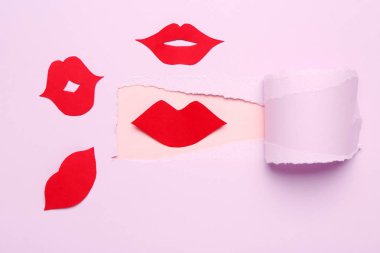 Kırmızı kağıt dudaklar leylak kağıdındaki delikten görülebilir.