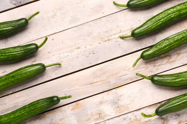 Hafif ahşap zemin üzerinde taze salatalıktan yapılmış bir çerçeve.