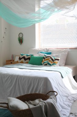 Yatak odası, yatak odası, komodin ve beyaz duvarda asılı düş kapanı.