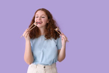 Leylak arka planında suşi yiyen genç bir kadın.