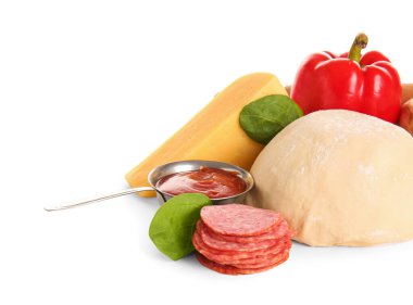 Beyaz arka planda pizza hazırlamak için ham hamur ve malzemeler