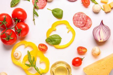 Beyaz arkaplanda pizza hazırlamak için gerekli malzemeler